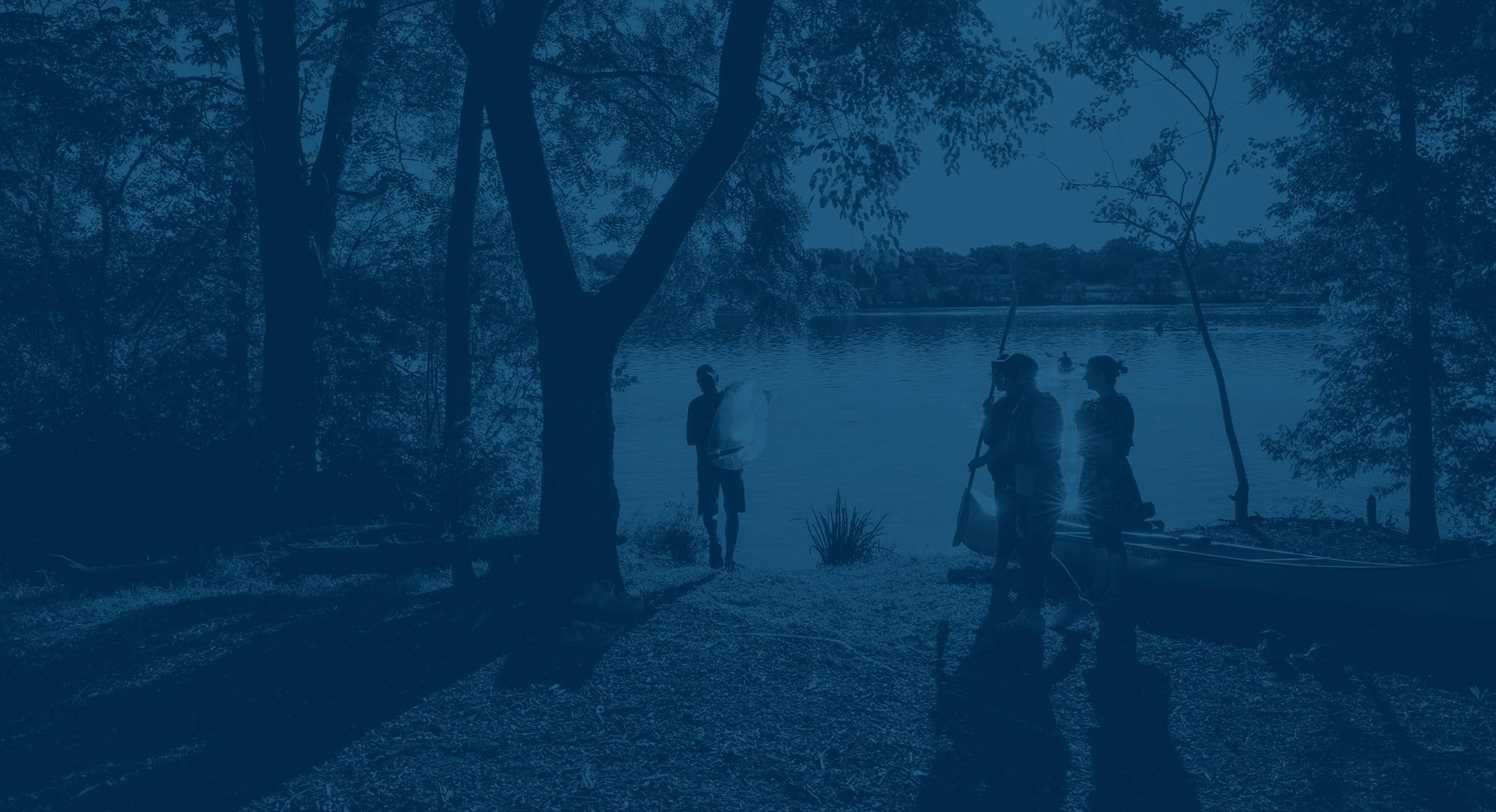 Students gather on the edge of the Rock River, preparing to go on the water.